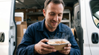 Delivery driver opening a hot ELYO lunch box in his van